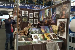 Stand d'une illustratrice spécialisée en art fantasy au Toulouse Game Show de Pau, avec affiches et prints exposés